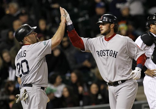 Boston Red Sox's Kevin Youkilis (20) greets teammate Jarrod Saltalamacchia at home after the pair scored on Saltalamacchia's second home run of the game, both off Chicago White Sox starting pitcher Philip Humber, during the fifth inning of a baseball game on Thursday, April 26, 2012, in Chicago. (AP Photo/Charles Rex Arbogast)