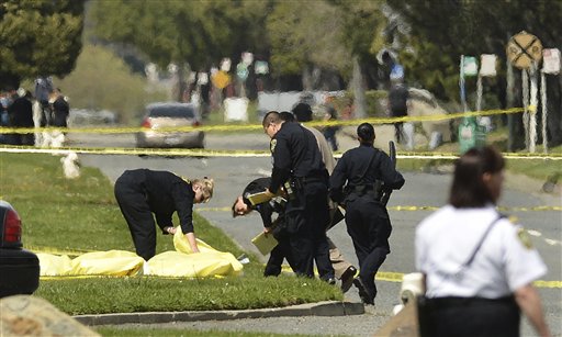 Police cover the bodies of some of the shooting victims near Oikos University in Oakland, Calif., today.