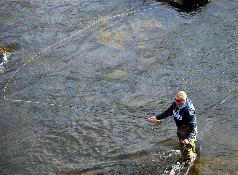 Staff Photo by Michael G. Seamans Nick Nichols, of New Sharon, takes advantage of the warm sunny Friday afternoon as he fly fishes in the Sandy River in Farmington.