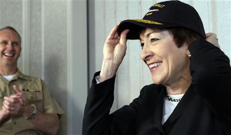 U. S. Sen. Susan Collins, R-Maine, smiles as she places a cap on her head while Chief of Naval Operations Admiral Jonathan Greenert laughs during a news conference at Bath Iron Works, in Bath, Maine, on Wednesday, April 4, 2012. (AP Photo/Pat Wellenbach)