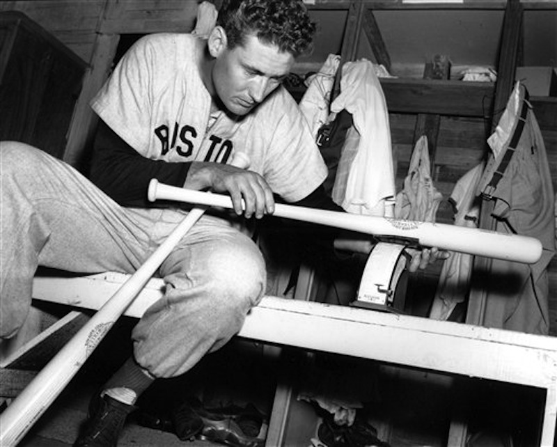 In this March 16, 1948 file photo, Boston Red Sox Ted Williams weighs one of his new 36-ounce Hickory baseball bats in the clubhouse after morning workout at spring training in Sarasota, Fla. (AP Photo)