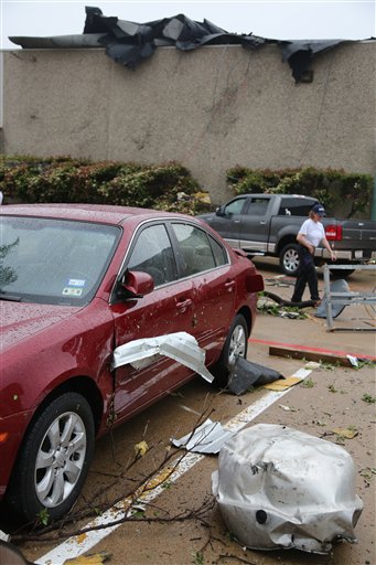 A car is damaged after a storm passed through in Arlington, Texas, today.