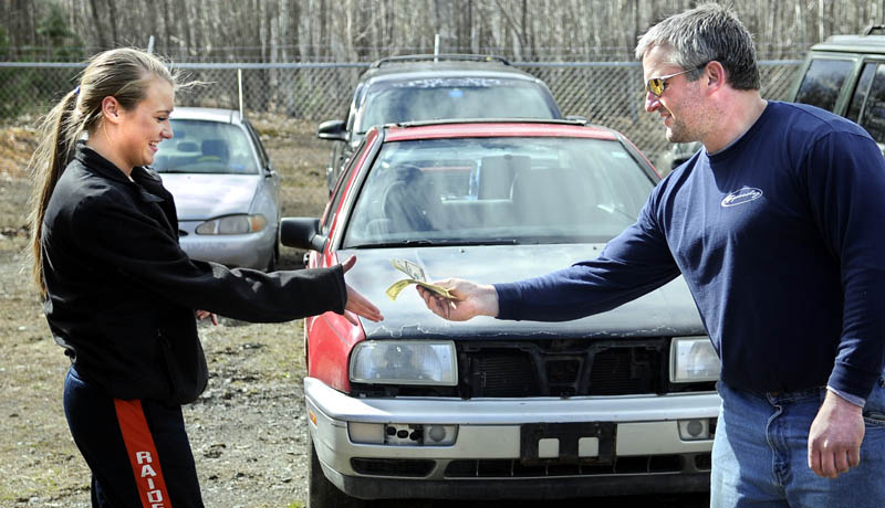 MONEY TRAIL: Rob Drummond, of Ready Road Service, hands 16-year-old Britany Whitaker $500 in cash Thursday from the sale of a car, center, that was impounded at his Augusta garage. The Jetta was seized from burglars who broke into Whitaker’s house in February.