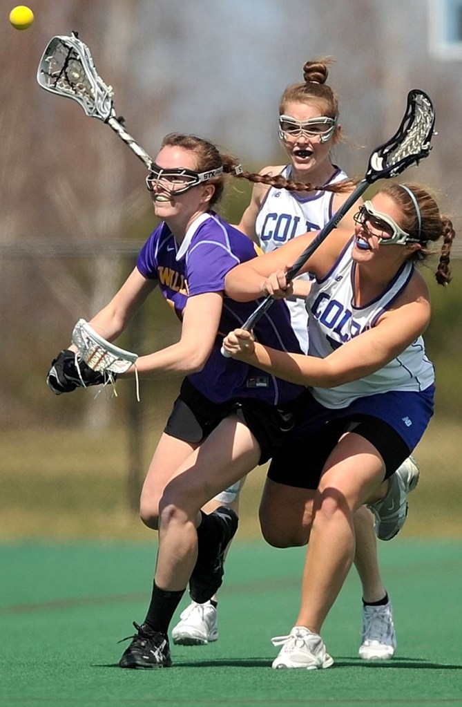 Staff Photo by Michael G. Seamans Williams College's Lacey Hankin, 12, left, battles with Colby Colleges Sarah Lux, 5, right and Kat McCarrick, 21, back, in the first period at Colby College in Waterville on Saturday.