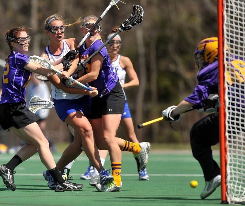 Staff Photo by Michael G. Seamans Colby College's Lindsey McKenna, 25, center left, shoots and scores as Williams College defenders, Lacey Hankin, 12, far left, and Grace Williams, 18, center, try to block the shot while Ali Pitch, 46, tries to make the save in the first period at Colby College in Waterville on Saturday.