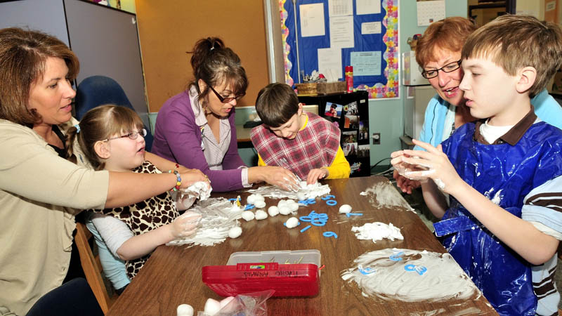 Winslow Elementary School education technicians work with autistic students in a Special Education class using a variety of sensory objects. Technicians with their respective students from left are Wendy Morrison with Madison Rowe, Anne Rice with Thomas Rowe and Linda Lemieux with Will Weiss.