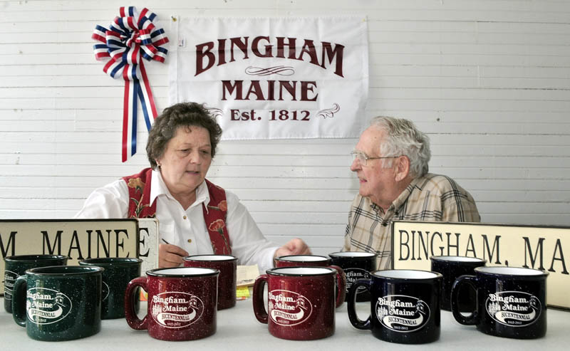 MILESTONE: Bingham Bicentennial co-chair Julie Richard and fundraising chairman Wes Baker set out items that will be sold during the town's bicentennial celebrations this summer.