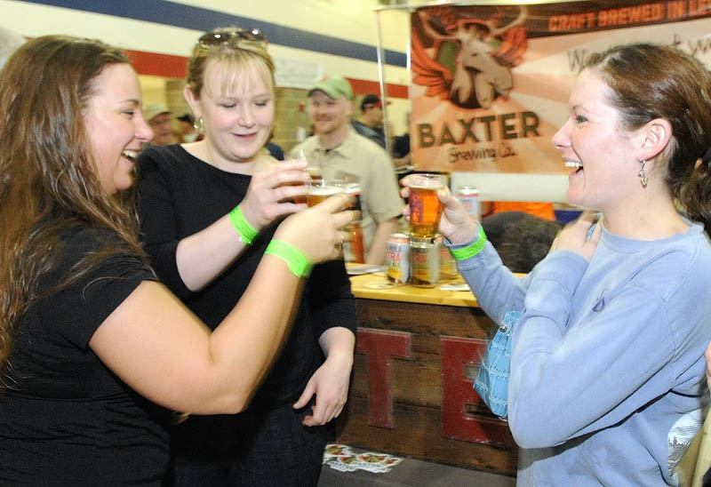 Amanda Hunnewell, left, Melonie Coutts and Molly Hendsbee clink their glasses in a toast Saturday during the Central Maine Brew Fest at Augusta State Armory.