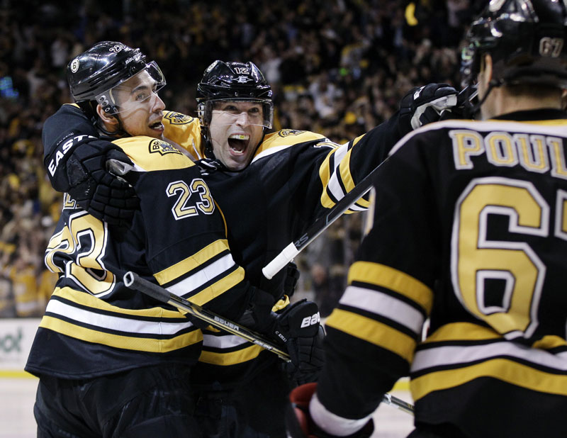 OT WIN: Boston Bruins center Chris Kelly (23) celebrates his game-winning goal with teammates Brian Rolston, middle, and Benoit Pouliot as the Bruins beat the Washington Capitals 1-0 in overtime in Game 1 of a Stanley Cup first-round playoff series Thursday in Boston.