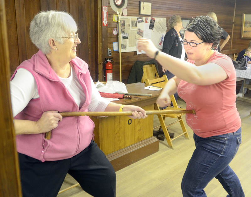 Instructor Karen Jones, owner of Tao Karate Club, right, demonstrates with Johan Brown how a cane can be used to push away an attacker during a self-defense demonstration on Saturday morning at the Chlesea Grange.