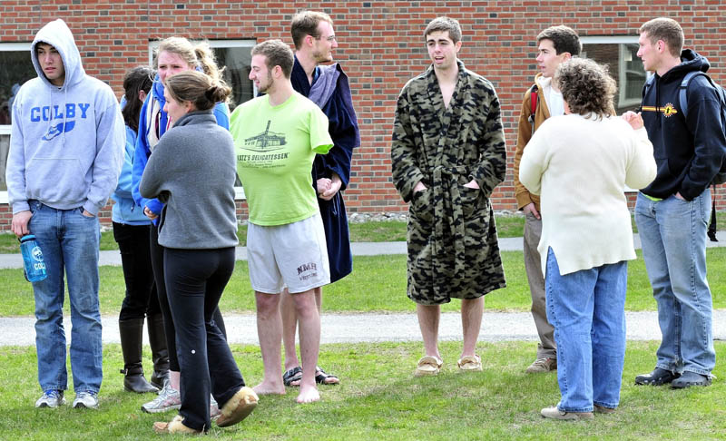 EARLY TO RISE: Colby College students, some barefoot and wearing bathrobes, were evacuated from the East Quad dormitory as firefighters extinquish a fire from an unattended lit candle that caused damage from fire, smoke and water on Thursday morning.