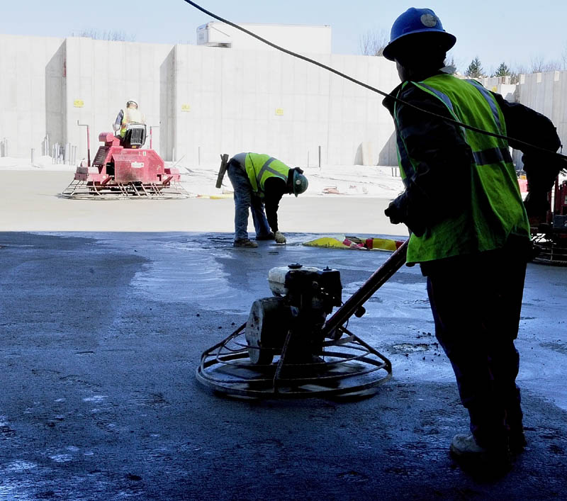 Workers from Newman Concrete Services, Inc. in Richmond, finish recently poured concrete last week at the new MaineGeneral regional hospital being built in Augusta.