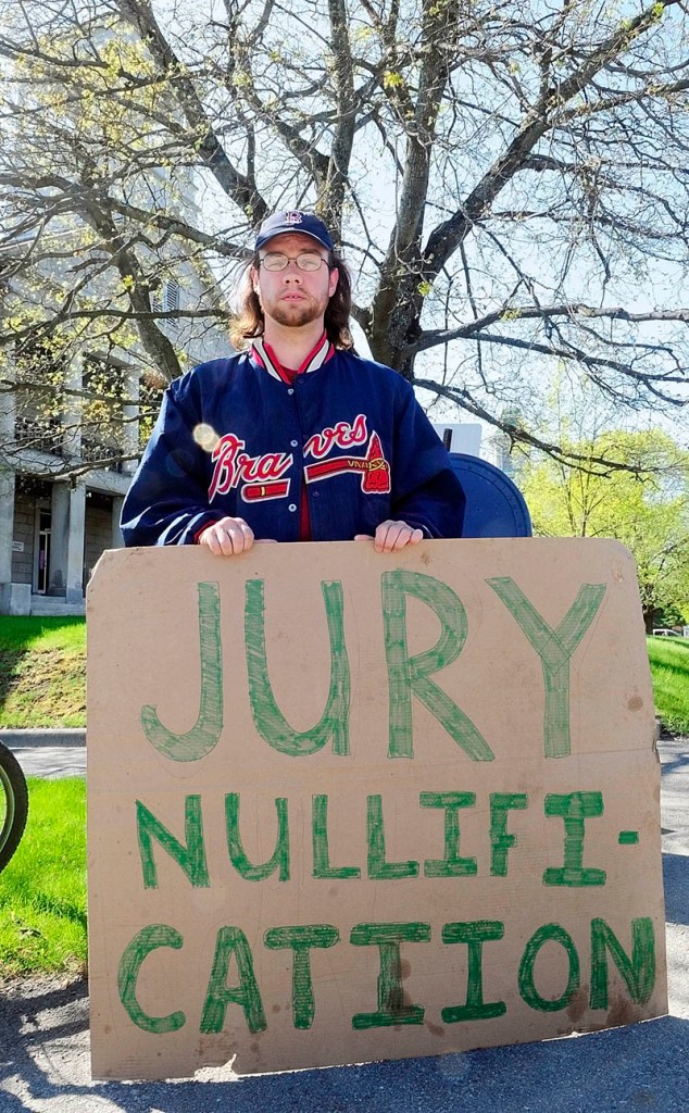 While a jury deliberates upstairs on the case of five Occupy protesters charged with trespassing at the Blaine House last November, Jarody holds a sign in front of Kennebec County Superior Court on Thursday morning in Augusta.