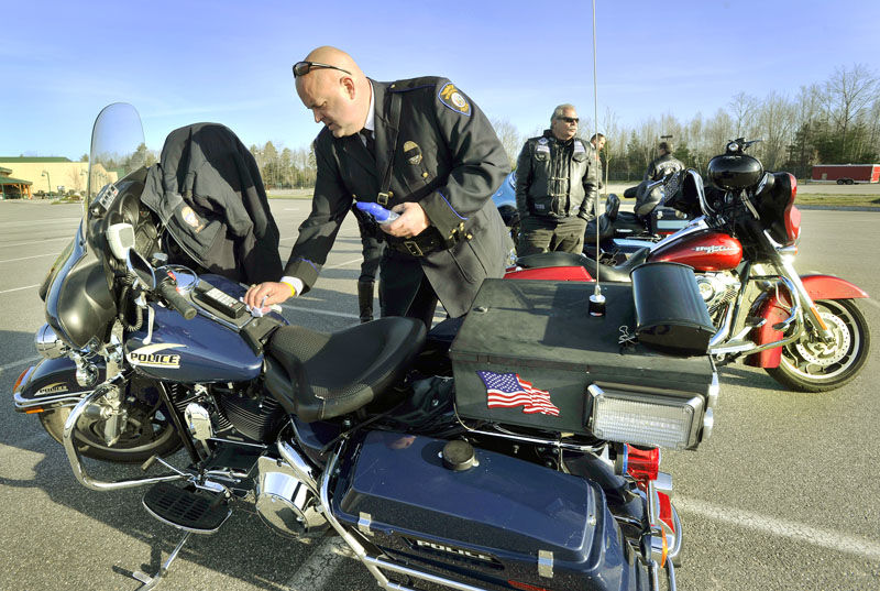 Detective Ray Williams of the Windham Police Department polishes his motorcycle before participating in the procession of law enforcement officers traveling to Greenland, New Hampshire to honor slain Police Chief Michael Maloney.