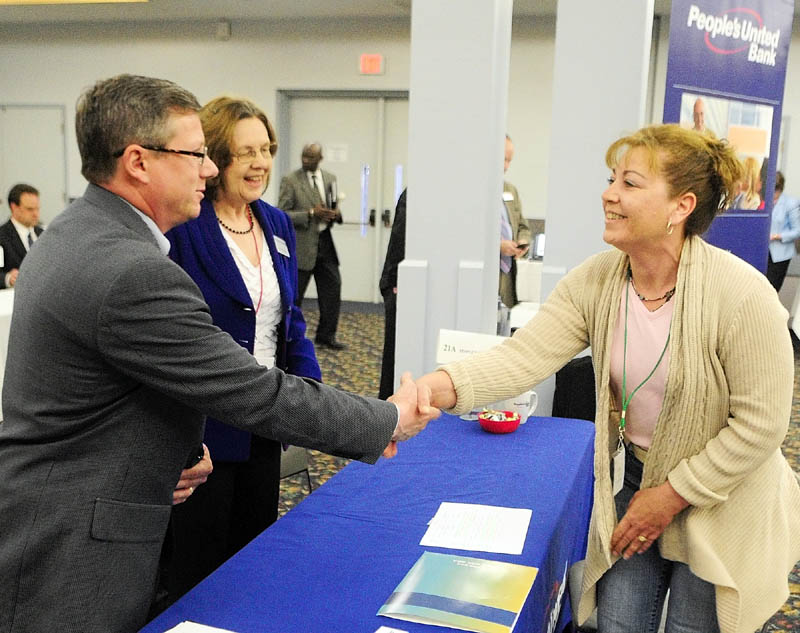 John Quesnel, left, and Victoria Burpee, of People's United Bank, greet Rachel Crommett, of West Forks, at the U.S. Small Business Administration-organized Meet the Lenders Speed Banking Conference on Wednesday at the Augusta Civic Center.