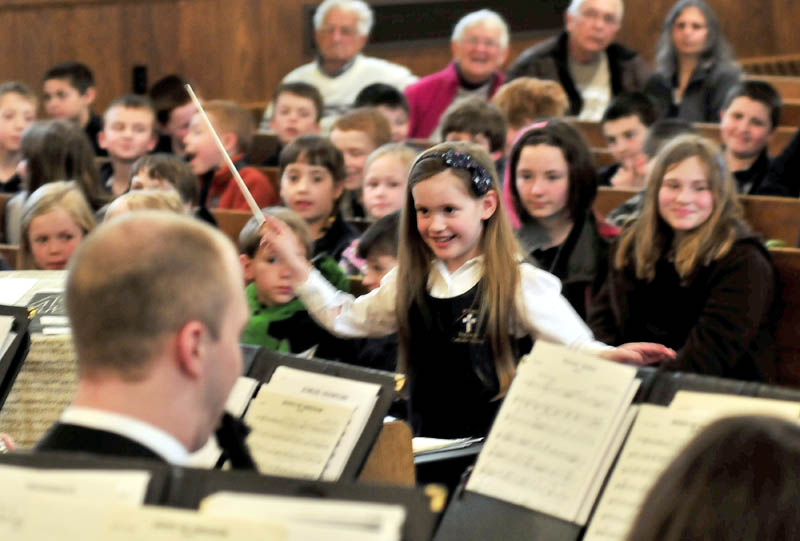 MAESTRO DEBUT: St. John's Regional Catholic School kindergarten student Camden Cotnoir was selected to be guest conductor of the University of Maine in Orono Symphonic Band that performed to students and parents at Sacred Heart Church in Waterville on Monday. Cotnoir's brief performnce drew a standing ovation and conductor Chris White gave her the baton she used. A smiling Cotnoir said she was nervous and added," I've never done this before."