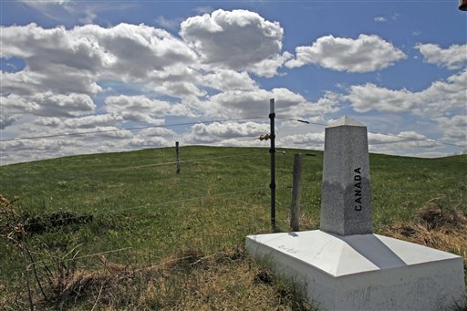 A marker in Stanstead, Quebec, locates the border in front of the proposed site of a U.S. wind turbine project in Derby Line, Vt.