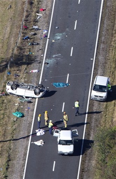 Police and fire crew examine the scene of a minivan crash near Turangi, New Zealand, Saturday, May 12, 2012. Three Boston University students who were studying in New Zealand were killed Saturday when their minivan crashed. At least five other students from the university were injured in the accident, including one who was in critical condition. (AP Photo/New Zealand Herald, John Cowpland) NEW ZEALAND OUT, AUSTRALIA OUT