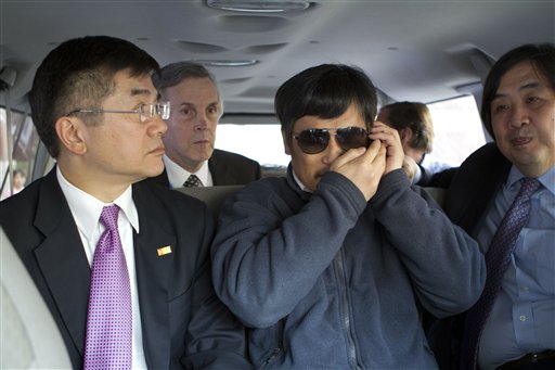 In this photo released by the US Embassy Beijing Press Office, blind lawyer Chen Guangcheng, center, accompanied by U.S. ambassador to China, Gary Locke, left, talks on a cellphone in a car en route from the U.S. Embassy to a hospital in Beijing, Wednesday. At second left is language attache James Brown and at right is U.S. State Department legal adviser Harold Koh.