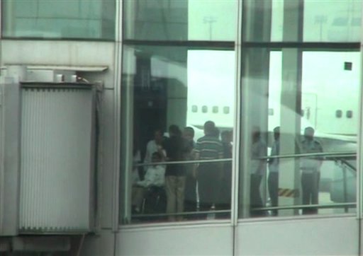 This video image taken from AP video shows blind Chinese activist Chen Guangcheng, left, pushed in a wheelchair from an elevator to a sky bridge that is connected to a plane at Beijing International airport Saturday May 19, 2012. A blind Chinese activist was hurriedly taken from a hospital Saturday and boarded a plane that took off for the United States, closing a nearly monthlong diplomatic tussle that had tested U.S.-China relations. Chen Guangcheng, his wife and their two children were on United Airlines Flight 88, which took off late Saturday afternoon from the Beijing airport. (AP Photo via AP video)