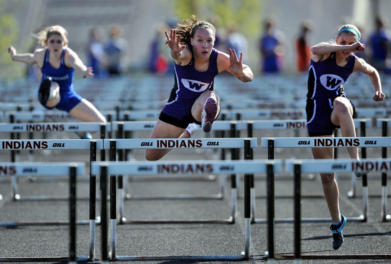 THE RACE IS ON: Waterville hurdlers Alex Jenson, center, and Olivia Thurston, right, and Lawrence High School’s Katie Dudley compete in the 100-meter hurdles at the Community Cup track and field meet Friday at Skowhegan Area High School. Jenson won the race with a time 15:08.