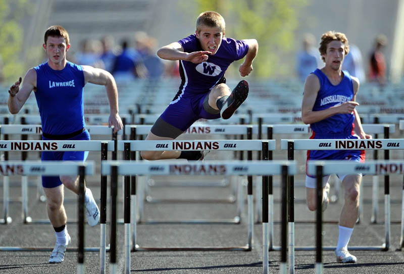 Waterville Senior High School's cpmepetes in the 110 meter hurdles at the Community Cup track and field meet at Skowhegan Area High School on Friday. Lawrence High School's Zachary Ricker is left and Messalonskee High School's Zach Sutherland is on the right.