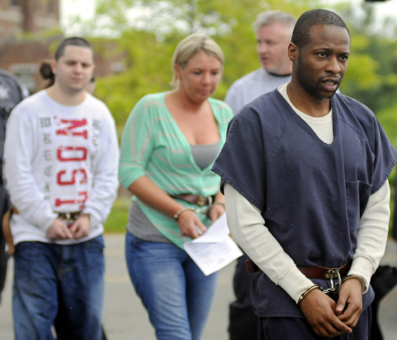 ARRESTS: Maurice McCray, right, leads a line of people arrested Tuesday morning — including Justin LaCroix and Tara Pelletier, at left, by federal and state authorities at the Maine Criminal Justice Academy in Vassalboro. A federal DEA agent is seen in the far back. Officers from several agencies said they made 10 arrests across central Maine stemming from a months-long drug investigation. Suspects were processed by federal agents at the Maine Criminal Justice Academy before being sent to jail.