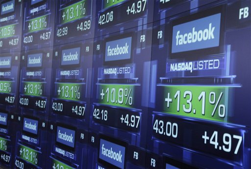 Electronic screens show the price of Facebook shares after they began trading today in New York.