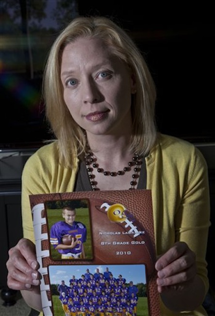 Kia LaBracke holds up a picture of her son in her home Friday, May 18, 2012, in Oconomowoc, Wis. LaBracke is concerned about her kids playing football in the wake of NFL concussions. (AP Photo/Morry Gash)