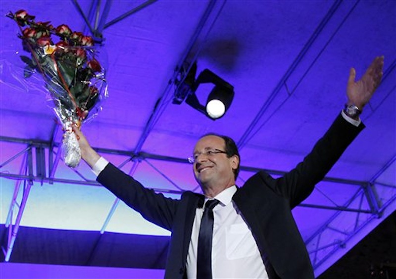 President-elect Francois Hollande holds a bouquet of roses after delivering his speech in Tulle, central France, Sunday, May 6, 2012. Francois Hollande defeated Sarkozy on Sunday to become France's next president, Sarkozy conceded defeat minutes after the polls closed. (AP Photo/Christophe Ena)