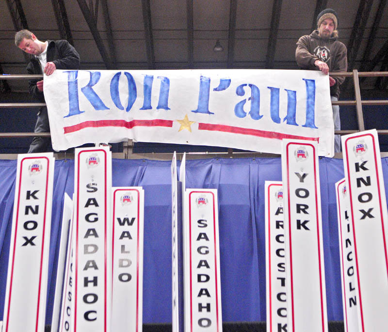 Toby Hoxie, of Hallowell, left, and Chad Libby, of Winthrop, hang up a sign for presidential candidate Ron Paul on Friday afternoon at the Augusta Civic Center. The state Republican convention opens this morning and runs through Sunday.