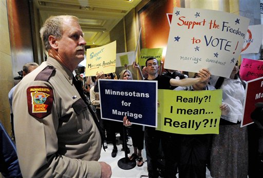 In this May 19, 2011 file photo, a state trooper stands by as demonstrators on both sides of the gay marriage issue gather outside the Minnesota House in St. Paul, Minn. Poll after poll shows public support for same-sex marriage steadily increasing, to the point where it's now a majority viewpoint. Yet in all 32 states where gay marriage has been on the ballot, voters have rejected it. It's possible the streak could end in November 2012, when Maine, Maryland, Minnesota and Washington state are likely to have closely contested gay marriage measures on their ballots. For now, however, there remains a gap between the national polling results and the way states have voted. (AP Photo/Jim Mone, File)