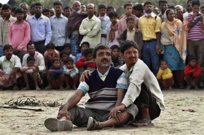 Abdul Mazid, 42, center, whose sister is missing anxiously watches rescuers pull out the wreckage of a ferry that capsized in the Brahmaputra River at Buraburi village, about 350 kilometers (215 miles) west of the state capital Gauhati, India, Tuesday, May 1, 2012. Army divers and rescue workers pulled more than 100 bodies out of a river after a packed ferry capsized in heavy winds and rain in remote northeast India, an official said Tuesday. At least 100 people were still missing Tuesday after the ferry carrying about 350 people broke into two pieces late Monday, said Pritam Saikia, the district magistrate of Goalpara district. (AP Photo/Anupam Nath)