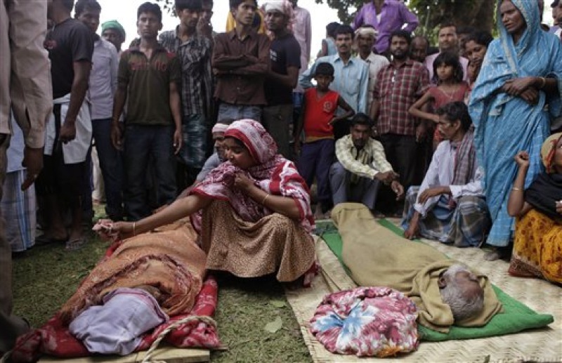 Relatives sit near the dead bodies of passengers who died after a ferry capsized in the Brahmaputra River at Buraburi village, about 350 kilometers (215 miles) west of the state capital Gauhati, India, Tuesday, May 1, 2012. Army divers and rescue workers pulled more than 100 bodies out of a river after a packed ferry capsized in heavy winds and rain in remote northeast India, an official said Tuesday. At least 100 people were still missing Tuesday after the ferry carrying about 350 people broke into two pieces late Monday, said Pritam Saikia, the district magistrate of Goalpara district. (AP Photo/Anupam Nath)