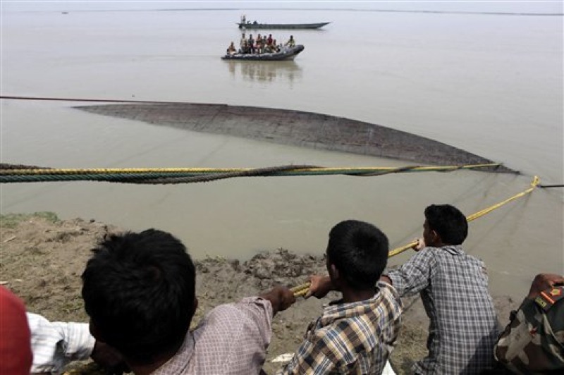 Rescuers pull out the wreckage of a ferry that capsized in the Brahmaputra River at Buraburi village, about 350 kilometers (215 miles) west of the state capital Gauhati, India, Tuesday, May 1, 2012. Army divers and rescue workers pulled more than 100 bodies out of a river after a packed ferry capsized in heavy winds and rain in remote northeast India, an official said Tuesday. At least 100 people were still missing Tuesday after the ferry carrying about 350 people broke into two pieces late Monday, said Pritam Saikia, the district magistrate of Goalpara district. (AP Photo/Anupam Nath)