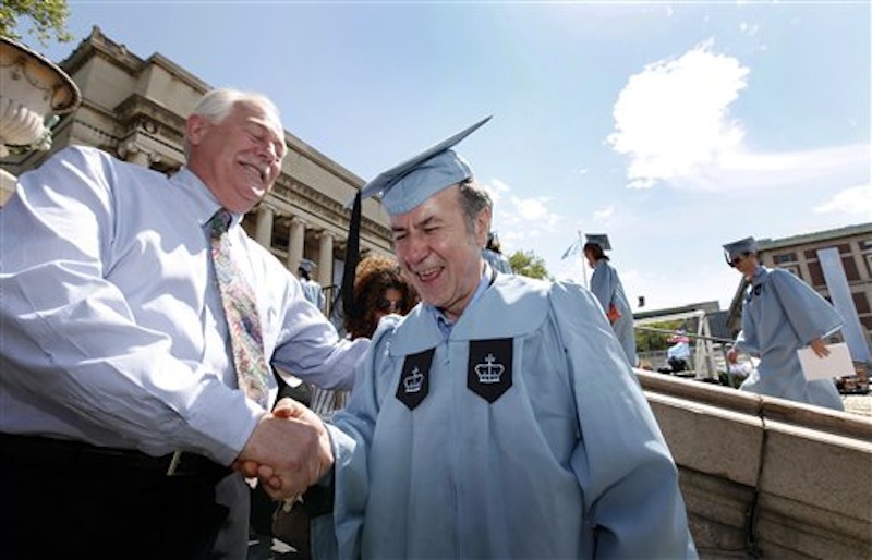Columbia University janitor Gac Filipaj, center, is congratulated by his boss, Donald Schlosser, the assistant vice president of facility operations, during the Columbia University School of General Studies graduation, Sunday, May 13, 2012, in New York. Filipaj, an ethnic Albanian who left his native Montenegro 20 years ago to escape war, is graduating with honors after 12 years of balancing studies and his full-time job. (AP Photo/Jason DeCrow)