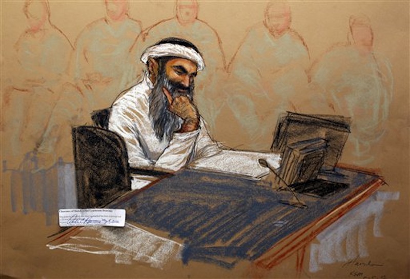 In this photo of a sketch by courtroom artist Janet Hamlin and reviewed by the U.S. Department of Defense, Khalid Sheikh Mohammed reads a document during his military hearing at the Guantanamo Bay U.S. Naval Base in Cuba, Saturday, May 5, 2012. The self-proclaimed mastermind of the Sept. 11 attacks repeatedly declined to respond to a judge's questions Saturday and his co-defendant was briefly restrained at a military hearing as five men charged with the worst terror attack in U.S. history appeared in public for the first time in more than three years. (AP Photo/Janet Hamlin, Pool)