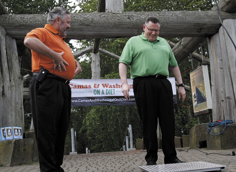 COMPETING: Sean Guard, left, mayor of Washougal, Wash., coaxes Camas Mayor Scott Higgins to step on the scales during their weigh-in last week in Washougal. The mayors of the two neighboring towns are in a "Biggest Loser"-style contest to see which of the two communities can lose the most weight. New government projections suggest roughly 42 percent of Americans will be obese by 2030.