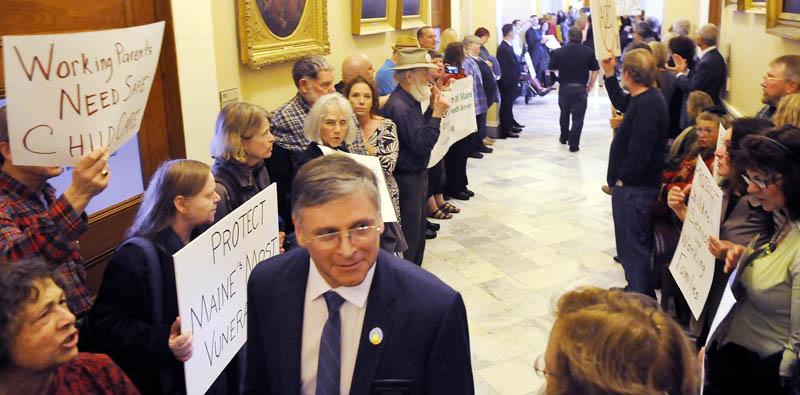DOING BETTER: Protesters chant Tuesday as Democrat Senator Chris Johnson, of Somerville, walks to a morning session at the Statehouse. A variety of groups, united as Maine Can Do Better, chanted between the House and Senate in opposition to a proposed budget.