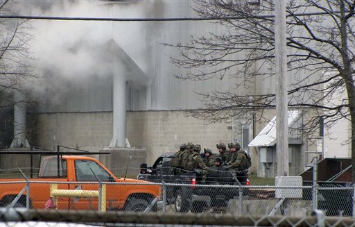 A team of Maine State Police tactical officers are taken by pickup truck into the Verso paper mill on March 14, 2012 in Jay during a standoff with a suspect Francis Smith III.