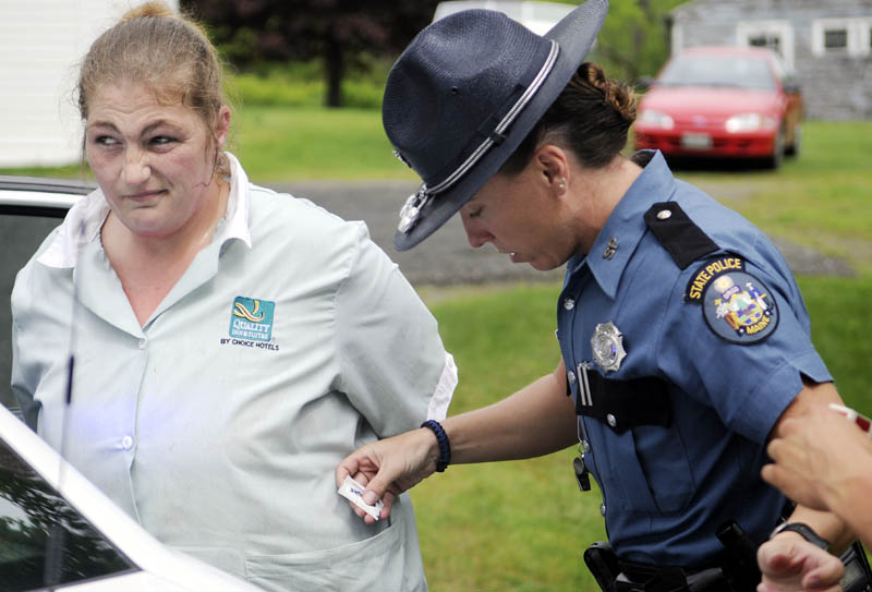 State Trooper Diane Perkins-Vance removes items from Angie Soucy's pockets moments after Soucy was arrested for allegedly dragging Kennebec County Deputy Nathan McNally with her car Tuesday in Belgrade. McNally stopped Soucy's vehicle and attempted to arrest her when she drove off with his hand stuck in her vehicle, according to police. McNally was not injured.