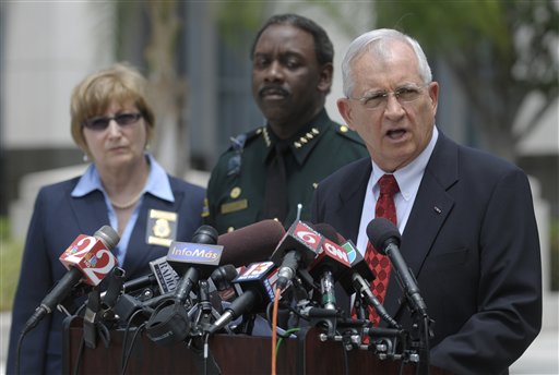 Florida State Attorney Lawson Lamar, right, announces charges against 13 people in the hazing death of Florida A&M University drum major Robert Champion during a news conference in Orlando, Fla., Wednesday, May 2, 2012. The charges were announced more than five months after Champion, 26, died aboard a chartered bus parked outside an Orlando hotel following a performance against a rival school. Standing next to Lamar are Florida Department of Law Enforcement Special Agent Joyce Dawley, left, and Orange County Sheriff Jerry Demings. (AP Photo/Phelan M. Ebenhack)