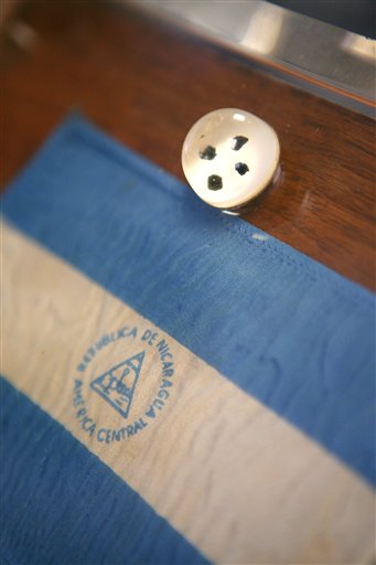 A container of moon rocks and a small Nicaraguan flag are shown at the office of lawyer Richard Wright Friday, May 18, 2012, in Las Vegas. The plaque and moon rocks were originally presented as a gift to the people of Nicaragua by President Nixon. (AP Photo/Las Vegas Review-Journal, Ronda Churchill)