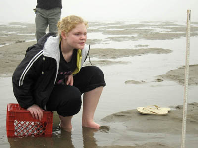 EYEING THE WAVES: Richmond High School junior Lauren Umberhind tries to gauge the height of waves in the rapidly rising tide at Popham Beach State Park on Wednesday morning. Students measured waves to compare them to periodic functions.