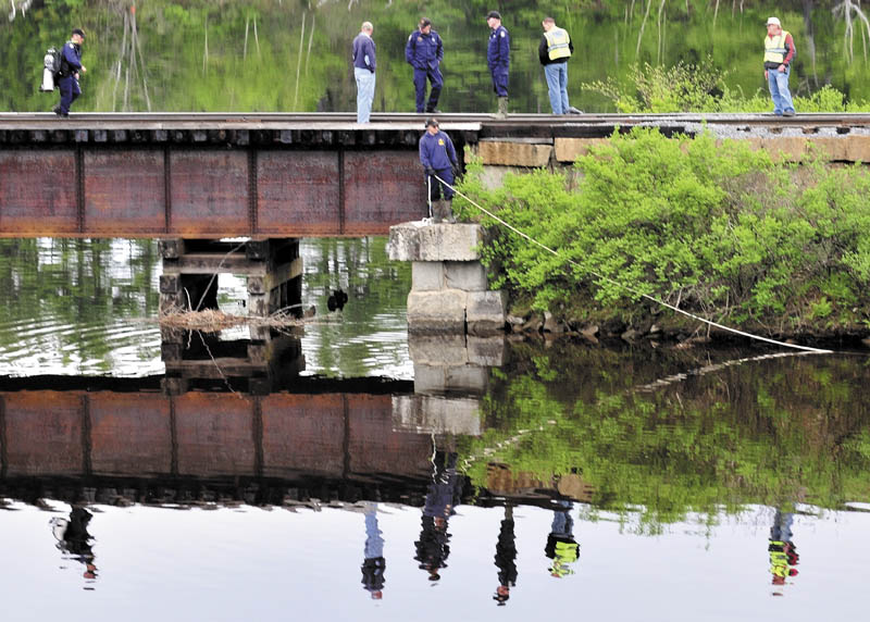 SEARCH: Maine State Police divers search Martin Stream near the Kennebec River off U.S. Route 201 in Hinckley on Sunday.