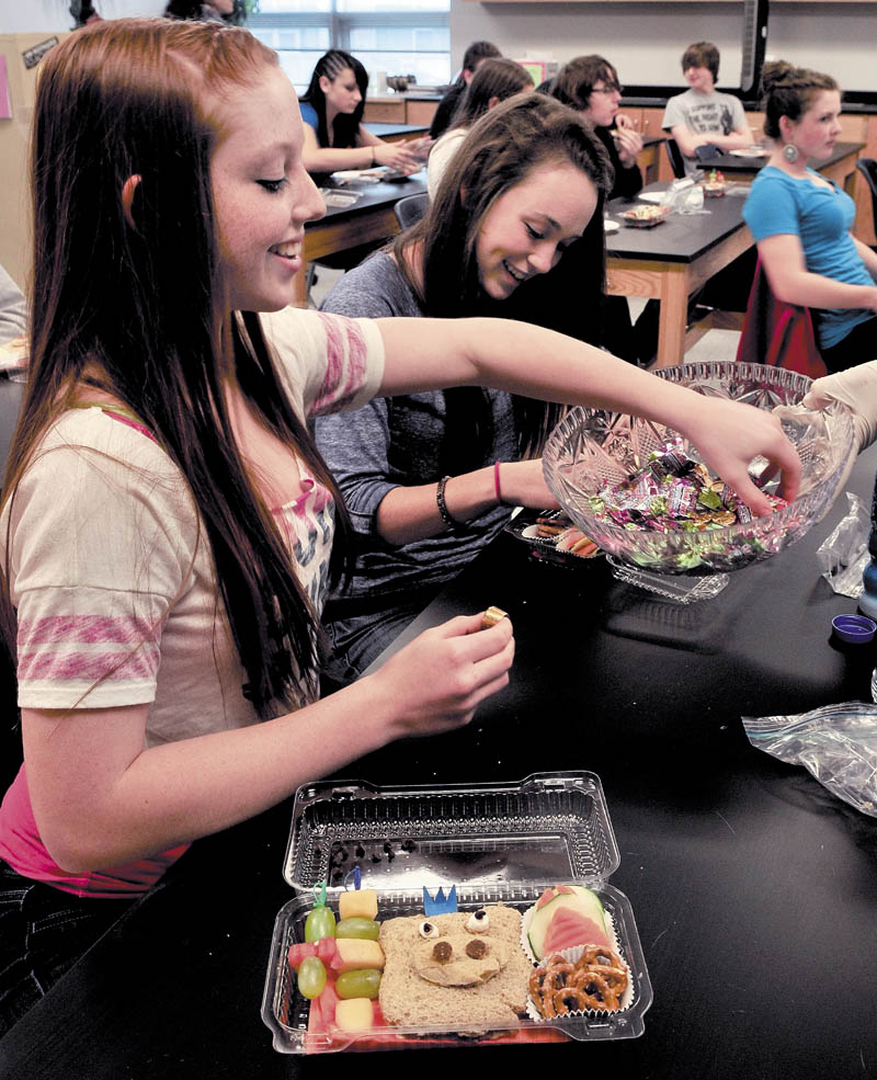 LUNCH IS SERVED: Waterville Senior High School students Kristi Yoos, left, and Amy Samson finish creating their Bento meal — a small boxed lunch consisting of protein, vegetables and fruit — in a workshop during Disease and Health Day on Wednesday.