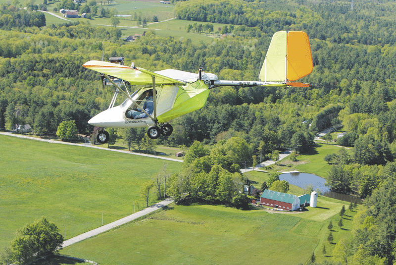 FLIGHT: Shawn Moody flies an experimental aircraft over Gorham on Friday. Moody and his friend John Pompeo have been flying the experimental aircraft for 20 years. Moody is looking to move the grass landing strip behind his Gorham home in order to create a longer runway.