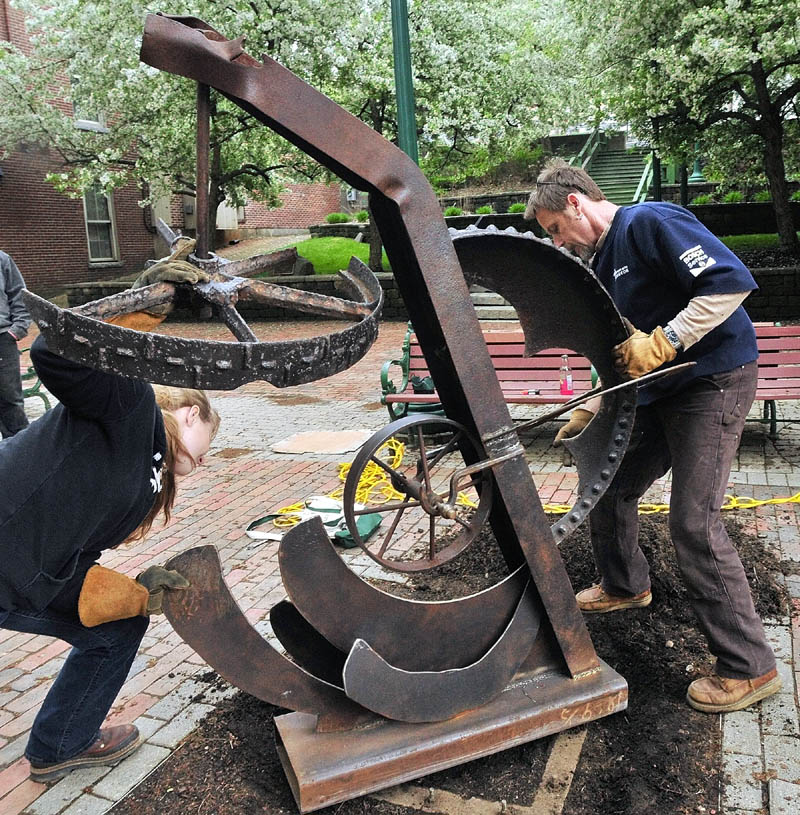 Katherine Herard, left, gets some help from Rob Lash as they install her sculpture "Ebb and Flow" in the Gardiner's Johnson Park on Thursday afternoon. The sculpture, which will be displayed through October, will be unveiled at 5:30 p.m. tonight as part of the Gardiner Artwalk. The event will take place from 5:30 to 9 p.m. throughout downtown. It was launched in the fall of 2005 by the Artdogs studios and a handful of area artists.