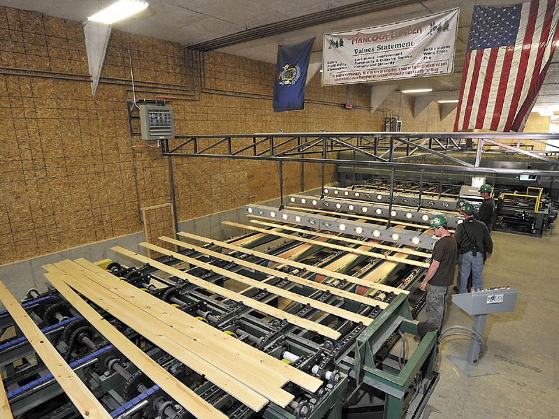 Custom work: Workers control the planed boards that are going to the machine that will cut them to exact lengths as requested by the customer at the Hancock Lumber Company in Casco. Customized orders are a specialty of Hancock Lumber.