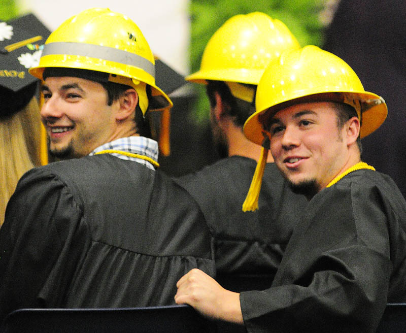 Chris Murphy, left, and Nathan Nixon, along with most of their Electrical Lineworker Technology fellow graduates, wore bright yellow hard hats instead of mortarboards for KVCC’s graduation.
